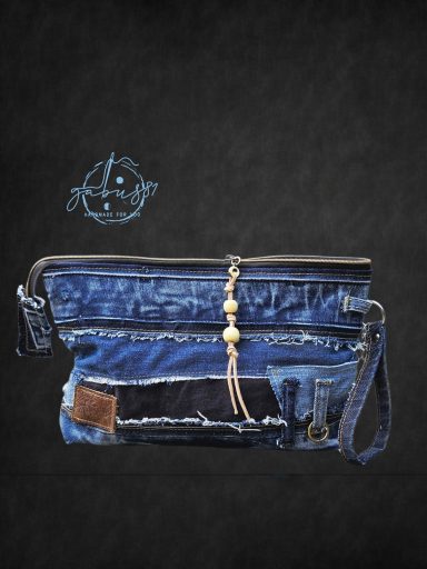Denim clutch bag with a decorative tassel and leather patch detail.