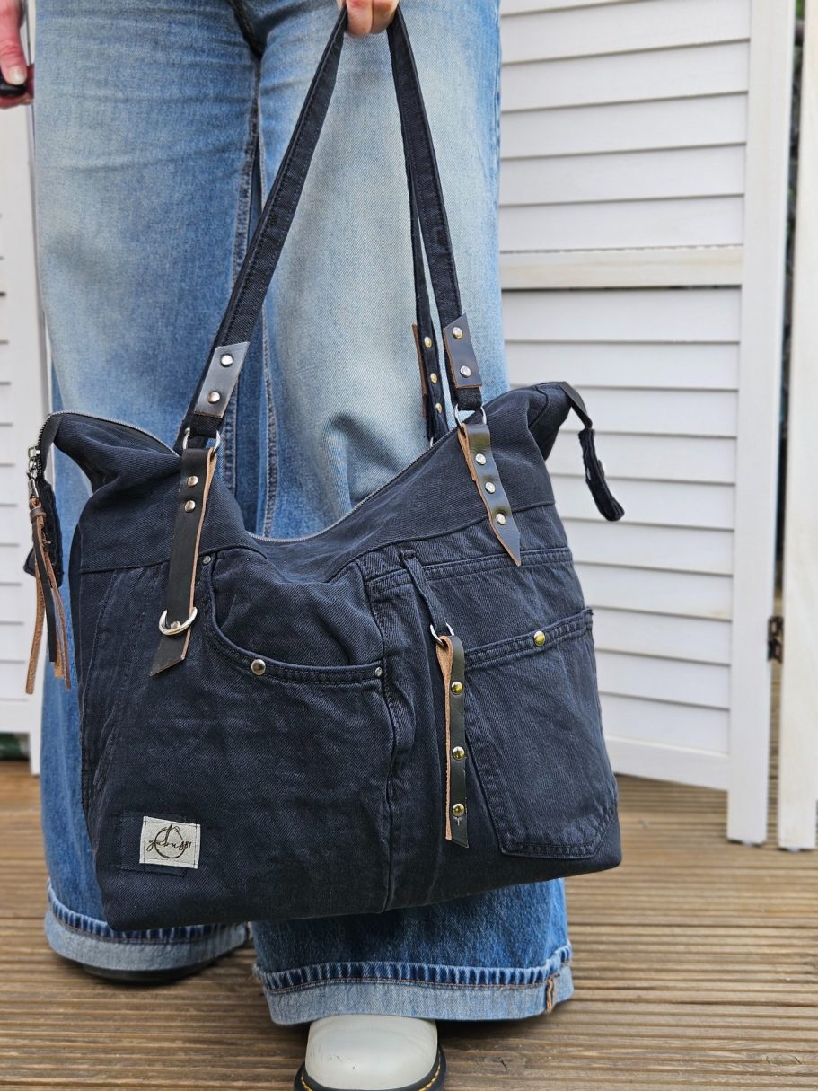 Handmade Denim Tote Black handmade denim tote bag side view, showing the depth, zip pulls and shoulder strap.