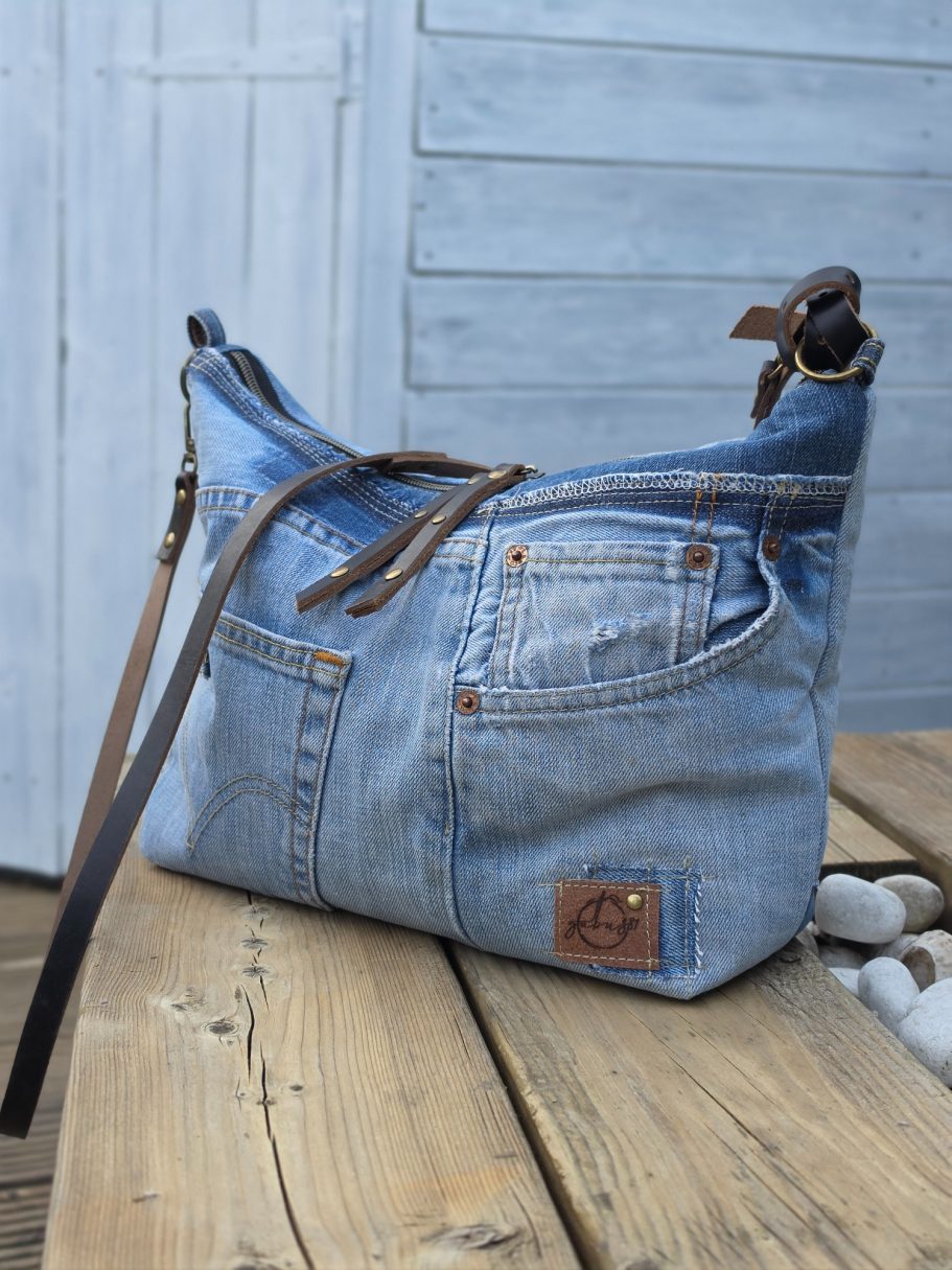 New in Shop Small upcycled denim crossbody bag made from rescued jeans with an adjustable strap and double zip opening.