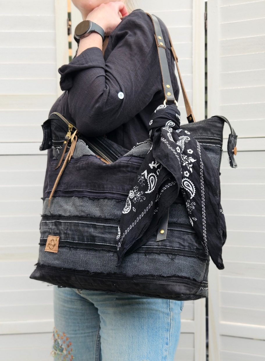 Black Denim Shoulder Bag Black denim tote bag held with a dark casual outfit, showing its everyday
