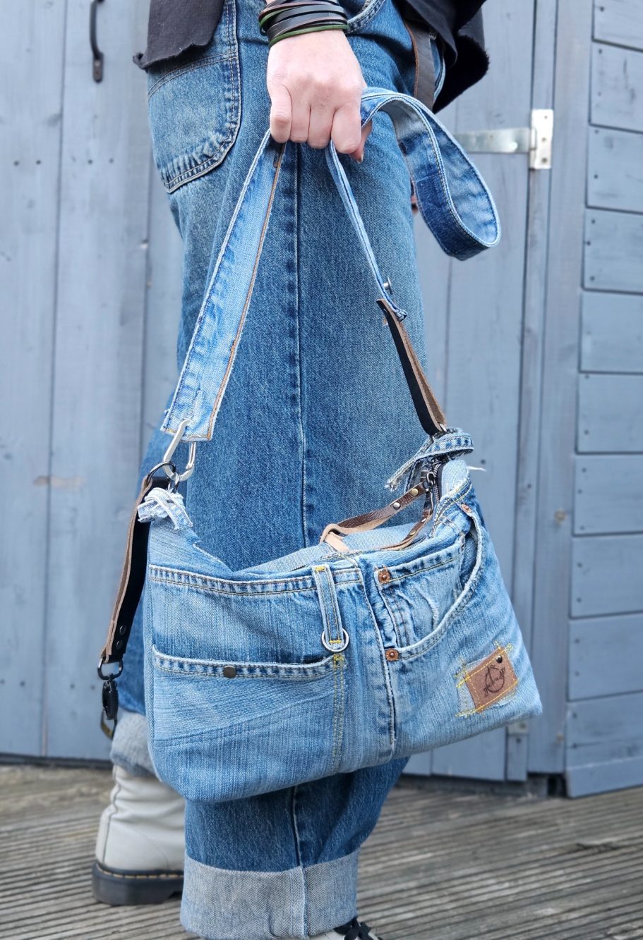 Denim Crossbody Bag - SOLD Medium denim crossbody bag made from reclaimed jeans, worn on the shoulder with original pocket details and leather strap accents.
