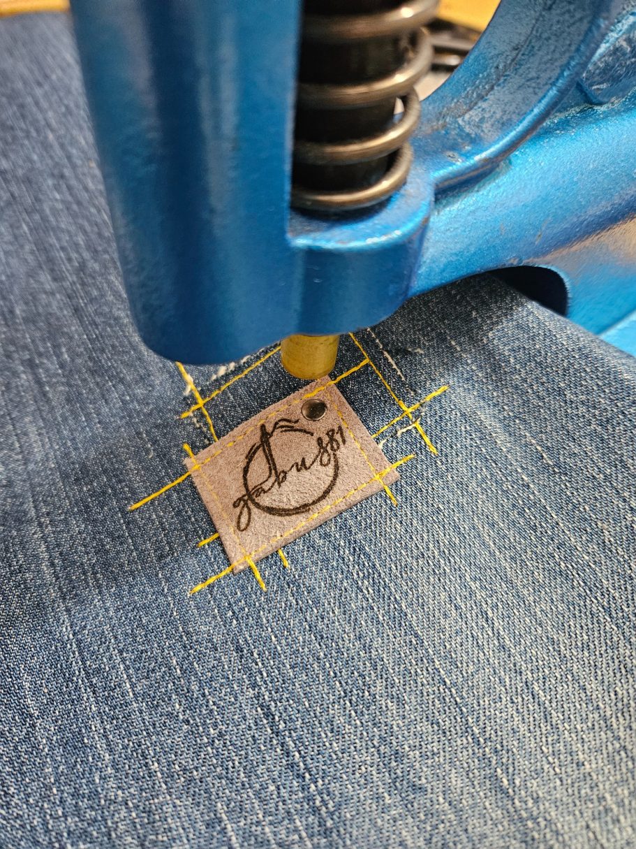 Making an Upcycled Denim Bag Gabus81 leather logo being sewn onto reclaimed denim